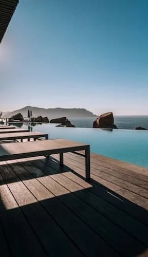 Clifftop terrace with glass railing and turquoise Pacific sea