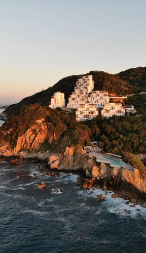 Infinity pool overlooking Acapulco bay and rocky coastline at Punta Marqués
